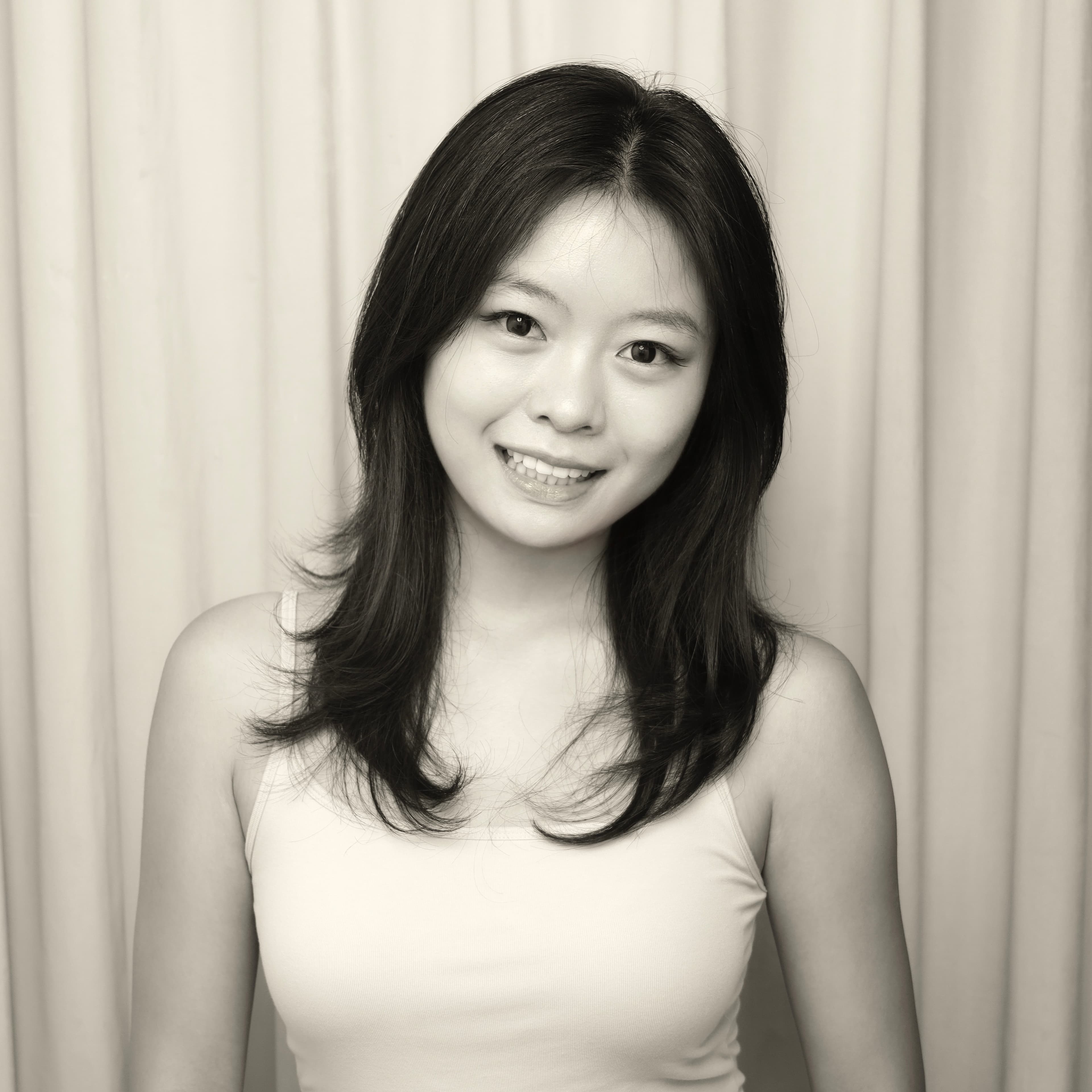 Alina smiling in front of curtains